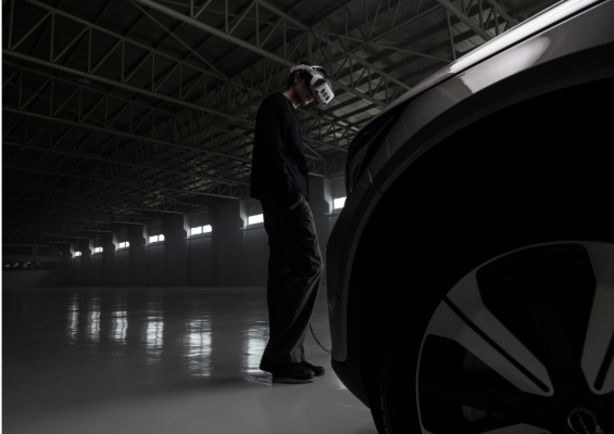 A person wearing a VR/XR headset looking a a car